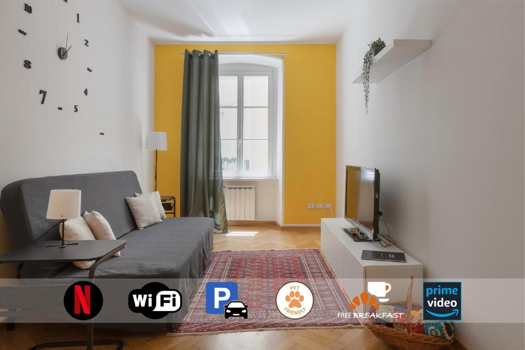 ein Wohnzimmer mit einem Sofa und einem TV in der Unterkunft Charme Bukowski, a Trieste centro con parcheggio in Triest