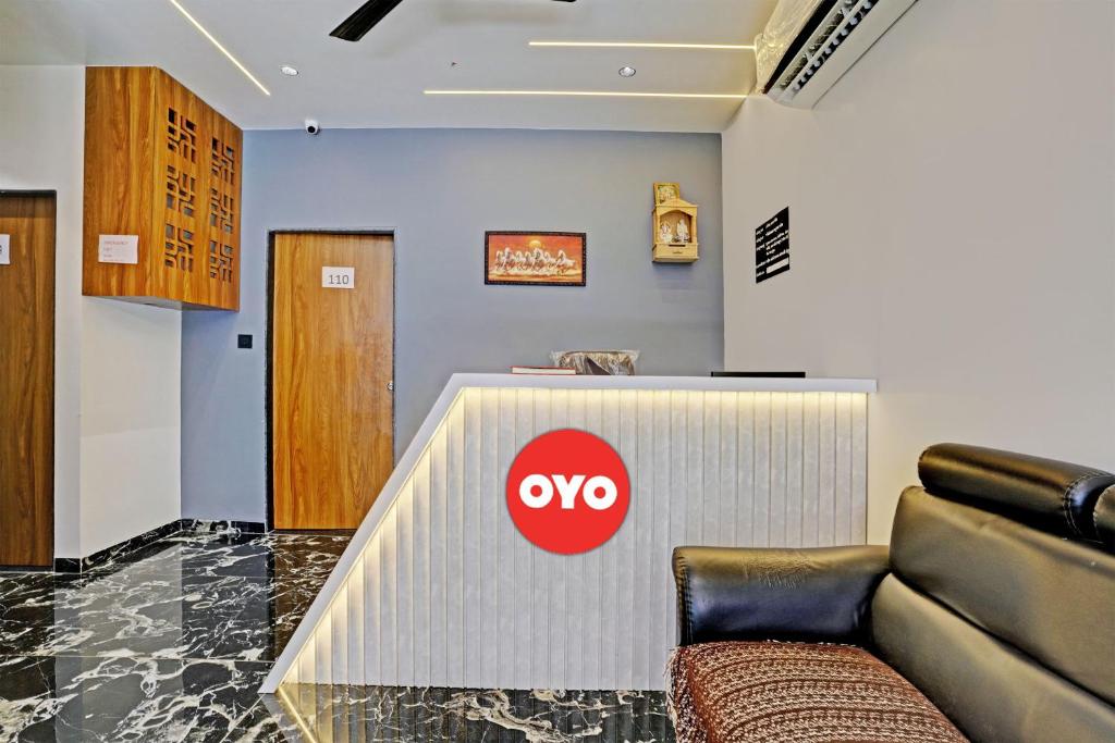 a lobby with a couch and aype sign on the wall at OYO Flagship Hotel Laksh View in Surat