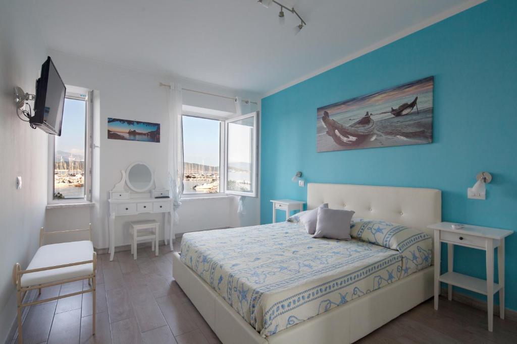 a bedroom with a bed and a blue wall at Fezzano / Portovenere Stilish double rooms with sea view, balcony or small courtyard in Fezzano