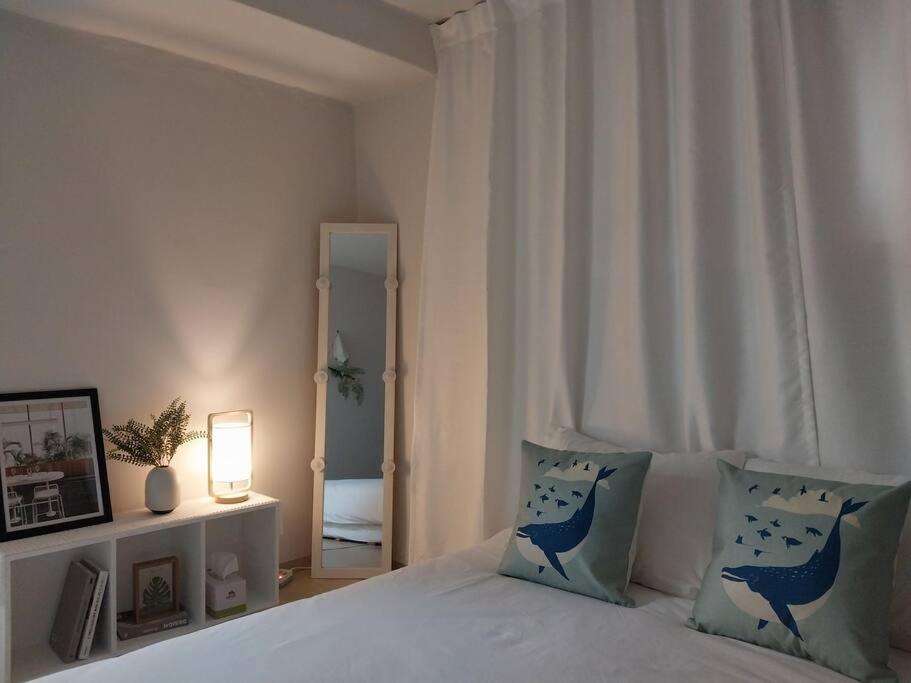 1 dormitorio con cama con almohadas azules y espejo en Time House - Dongdaemun district, en Seúl