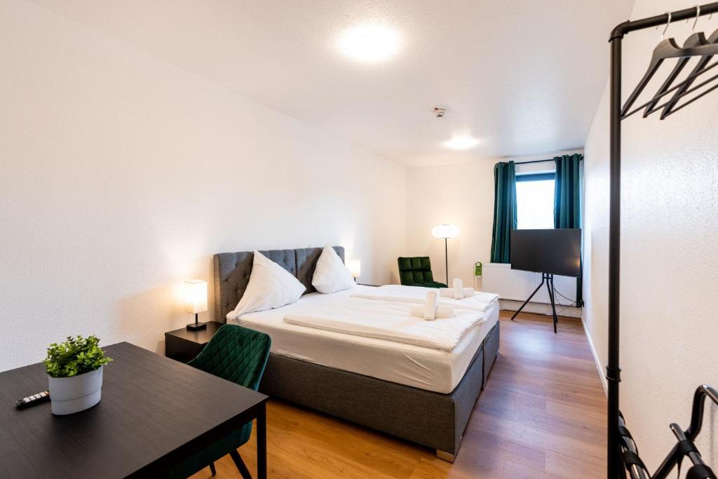 a bedroom with a bed and a table and a desk at Dream Factory by Hotel Bergheim in Bergheim