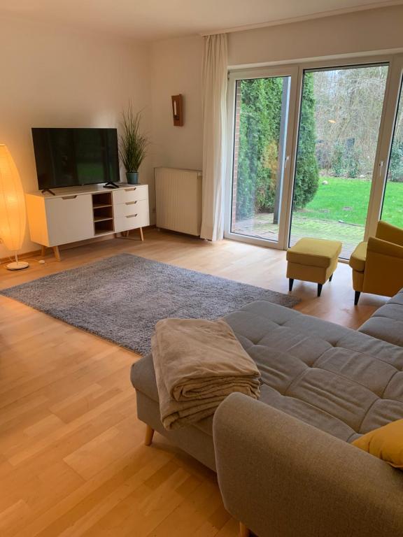 un salon avec un canapé et une télévision dans l'établissement Sonniges Garten-Apartment in ruhiger Parklage, à Bad Segeberg