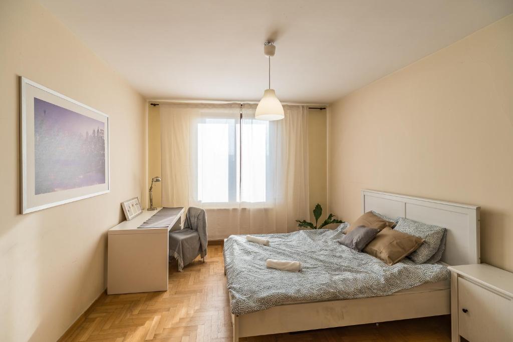a bedroom with a bed and a desk in it at Kraków Charm in Krakow