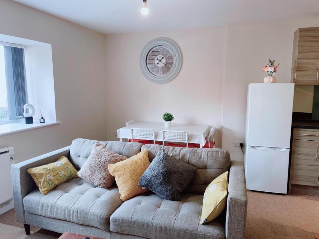 a living room with a couch with pillows at GALAXY APARTMENT in Stockport