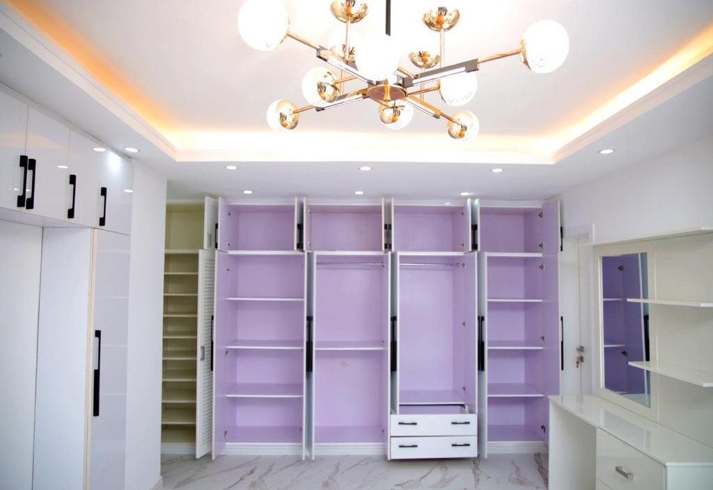 a closet with purple walls and a chandelier at Homestead Realestate in Addis Ababa
