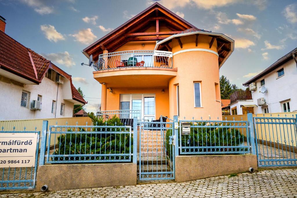 una casa con una valla azul delante de ella en Termálfürdő Apartman Igal 2 perc a fürdőtől, en Igal