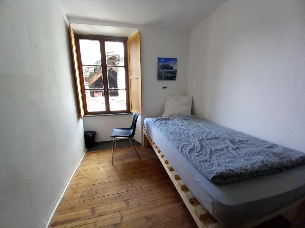 a small bedroom with a bed and a window at Room in Apartment - Casa Coerente Cavergno Room no 4 in Cevio