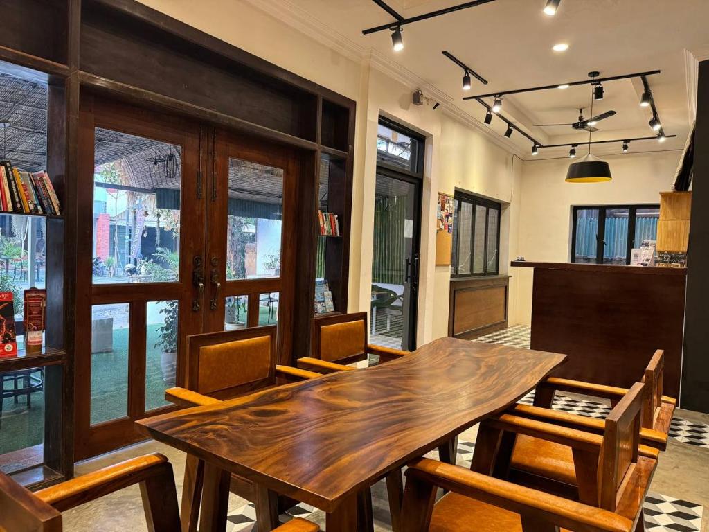 The Hive Hotel في سيام ريب: غرفة طعام مع طاولة وكراسي خشبية