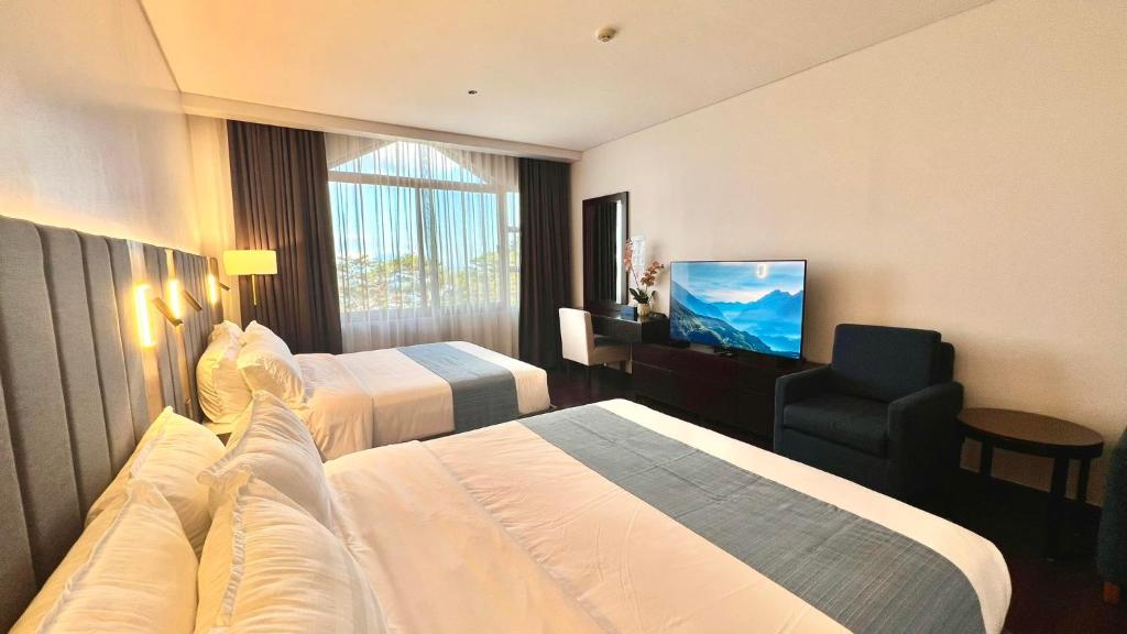 una camera d'albergo con due letti e una televisione di Mountain View,Room 549 Private Unit at The Forest Lodge,Camp John Hay Suites a Baguio