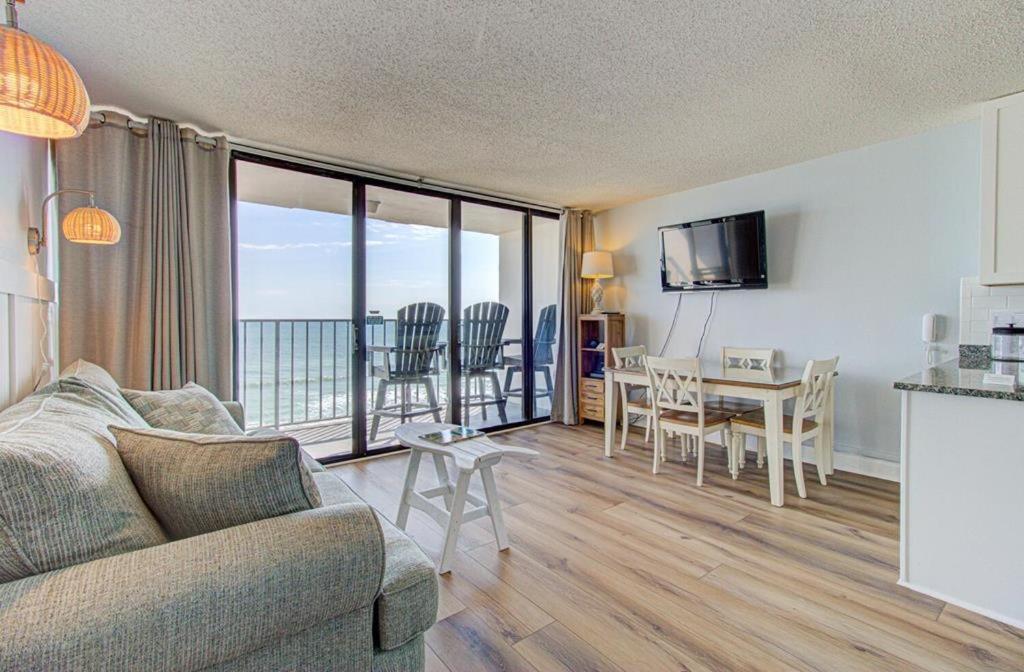 a living room with a couch and a table at 0705 Palms That Sway by Atlantic Towers in Carolina Beach