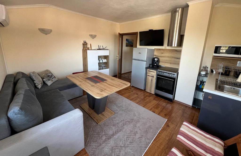 a living room with a couch and a table and a kitchen at VV Apartment Bansko in Bansko