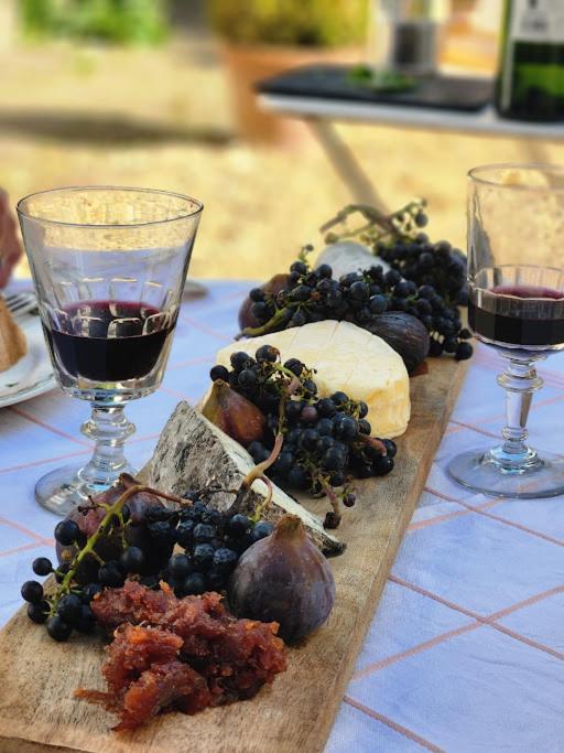 a table with two glasses of wine and some food at Gîtes du Manoir de la Porte in Les Authieux-sur-Calonne