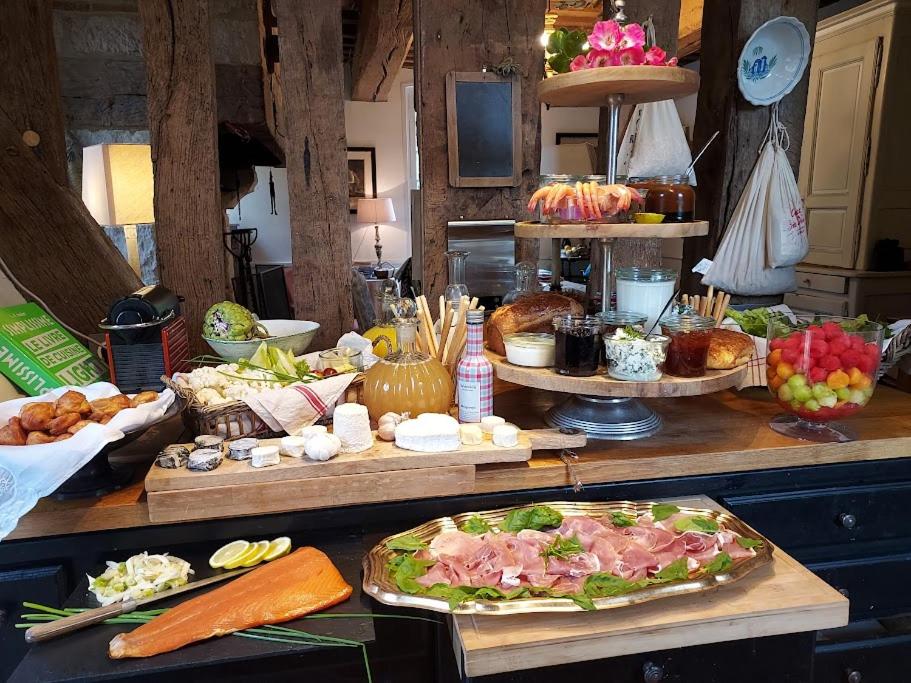 a buffet with many different types of food on a table at Gîtes du Manoir de la Porte in Les Authieux-sur-Calonne