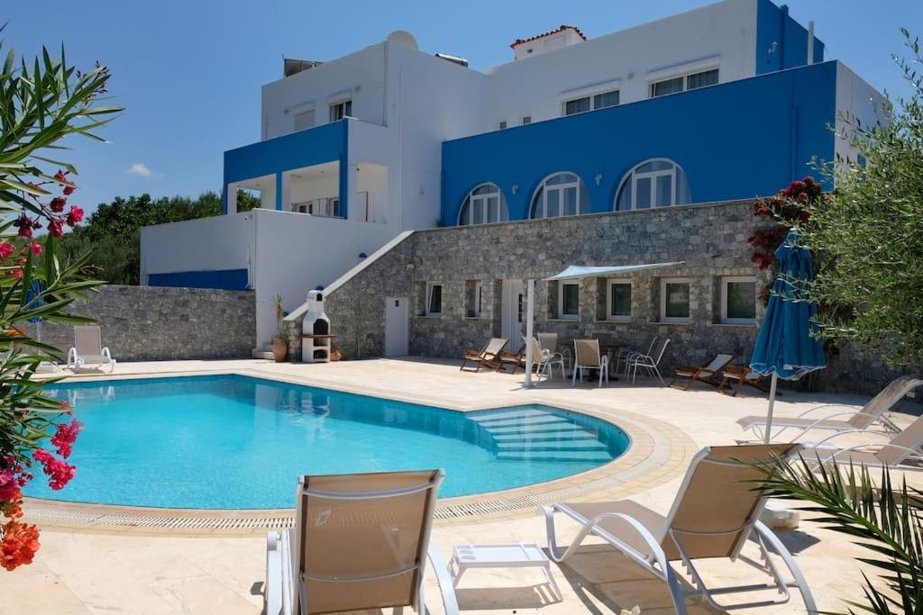 a swimming pool with chairs and a building at Villa Oliv sea view / LGBT friendly in Skaleta