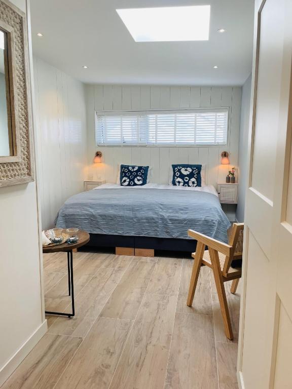 a bedroom with a large bed and a table at Villa de Duinfazant in Bergen aan Zee