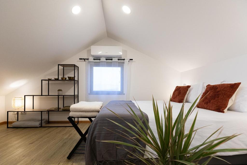 a bedroom with a bed and a chair and a window at Casinha da Praia - Beachside Retreat Almoxarife in Praia do Almoxarife
