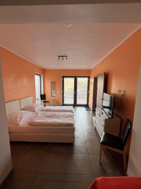ein Schlafzimmer mit einem Bett und einem TV in der Unterkunft Pension Unterreichenbach in Schwabach