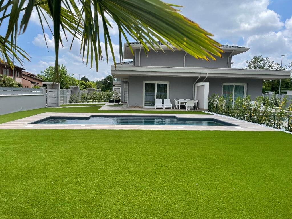 a house with a lawn and a swimming pool at Polinesia 6 in Lido delle Nazioni