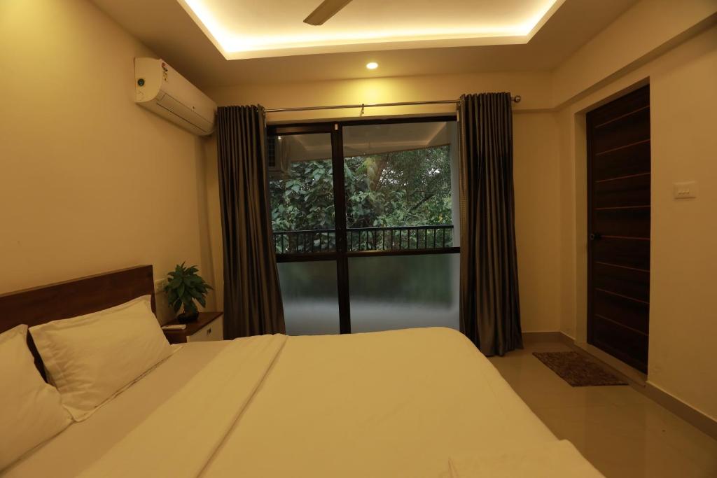 a bedroom with a bed and a large window at Vvp Airport Lounge in Nedumbassery