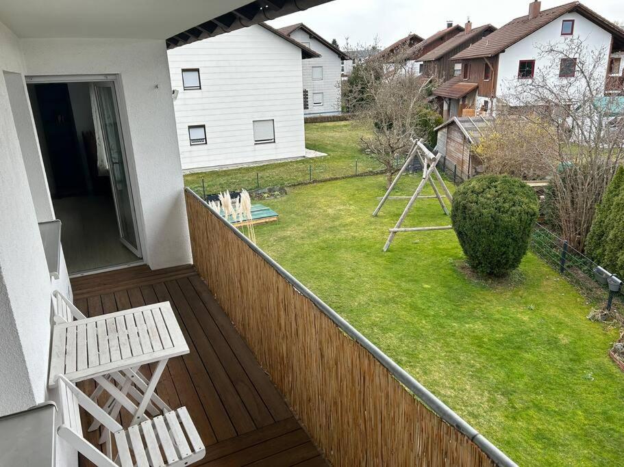 un balcón con un banco blanco y un patio en Ferienapartment Allgäu-Idyll, en Dietmannsried