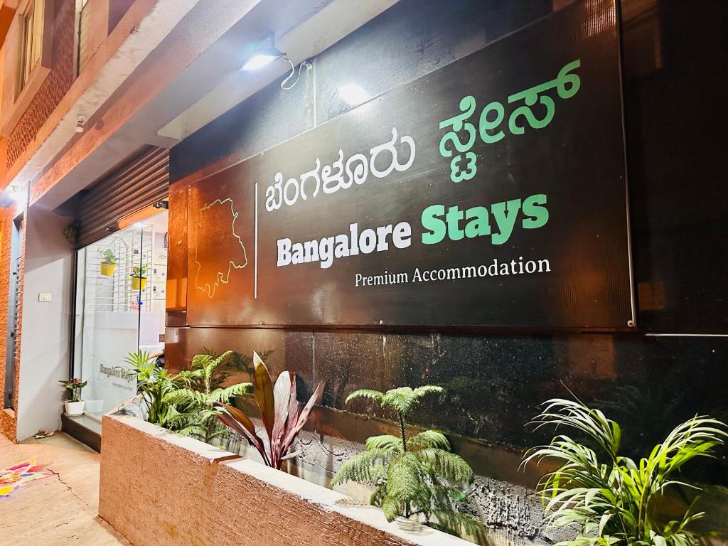 una señal en el lado de un edificio con plantas en Bangalore Stays, en Bangalore