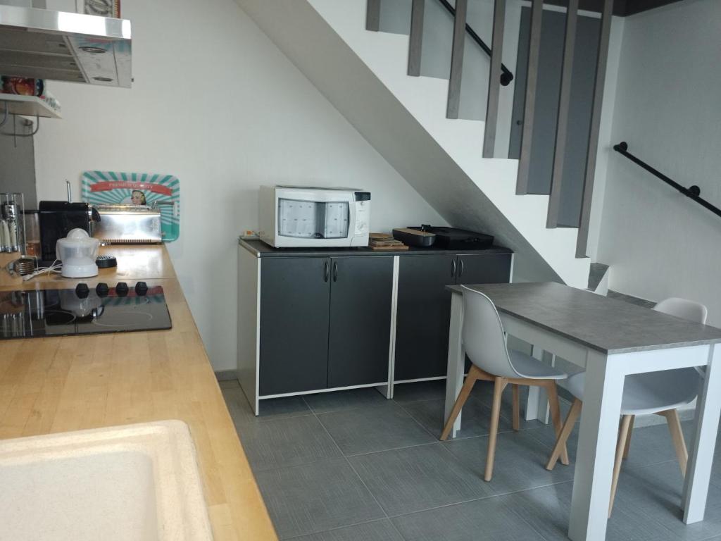 a small kitchen with a table and a microwave at Loc5c in Noirmoutier-en-l&#39;lle