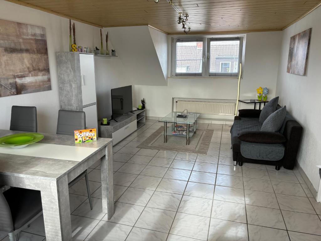 een woonkamer met een bank en een tafel en stoelen bij Charmante DG Whg Zentrumsnah in Mönchengladbach