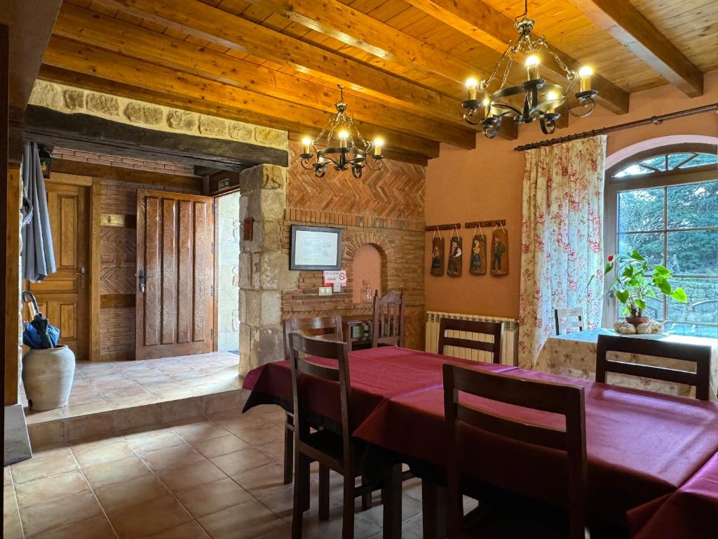 a dining room with a red table and chairs at Casa Rural La Socarrena in Luzmela