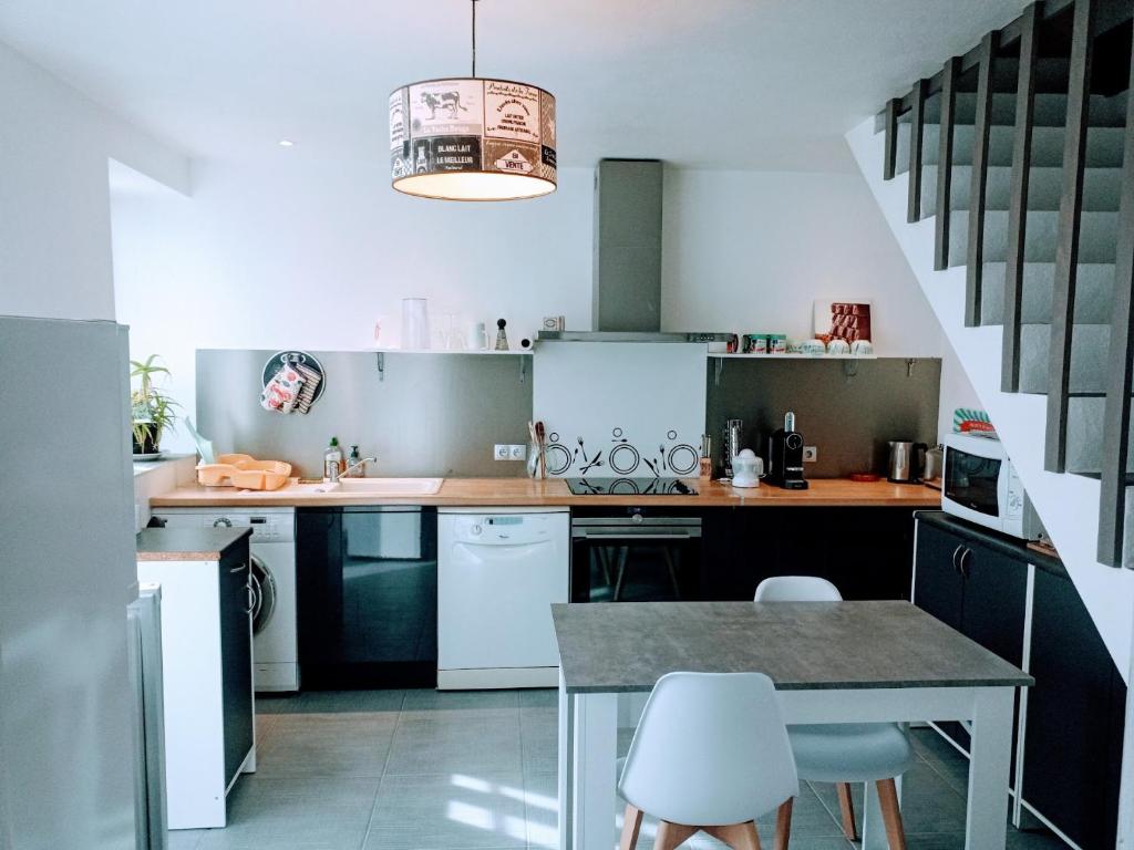a kitchen with a table and chairs in it at Loc5c in Noirmoutier-en-l&#39;lle