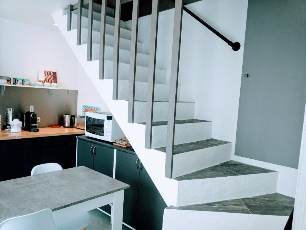 a staircase in a kitchen with a table and a microwave at Loc5c in Noirmoutier-en-l&#39;lle