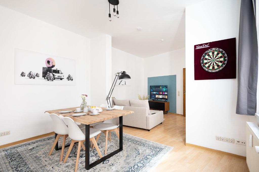 a living room with a dining table and a dartboard on the wall at Ko-Living Space an der Oper - Street Art Design Apartments in Halle an der Saale