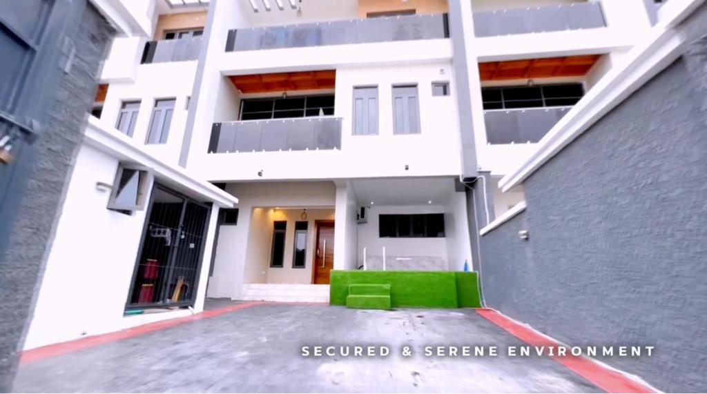 a white building with a green couch in front of it at Newly built Smart 4 bed rooms duplex in Ilasan ikate lekki in Lekki