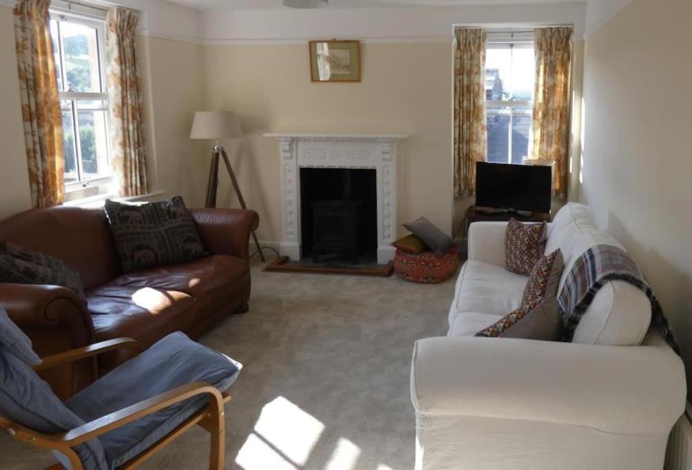 a living room with two couches and a fireplace at Cotswolds cottage near Stroud, with amazing views. in Brimscombe