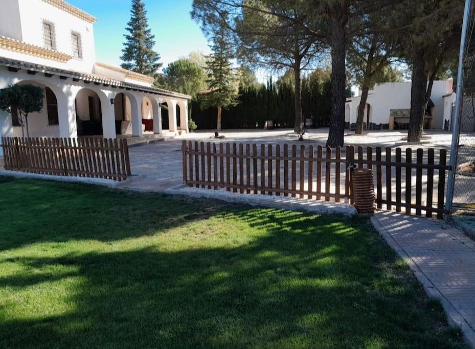 ein Holzzaun vor einem Haus in der Unterkunft Villa privada piscina-tenis in Villarrobledo