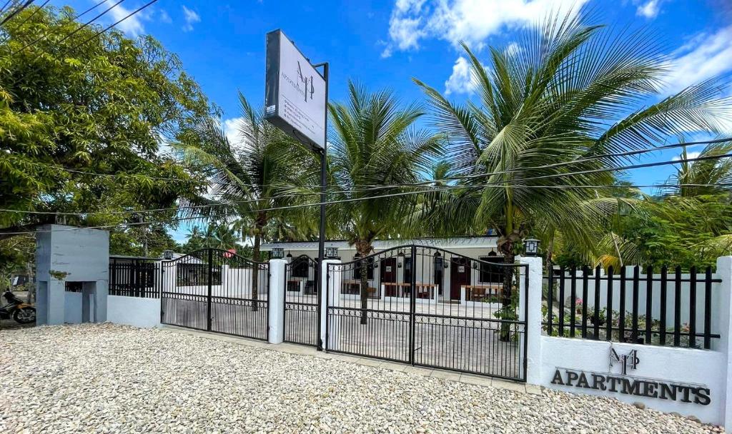 um portão em frente a um restaurante com palmeiras em MP Apartments Leyte em Hindang