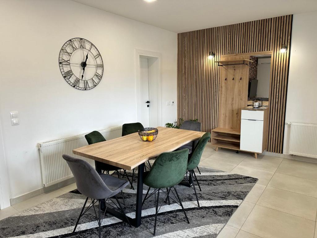 a dining room with a wooden table and green chairs at Divine Apartment Drnis in Drniš