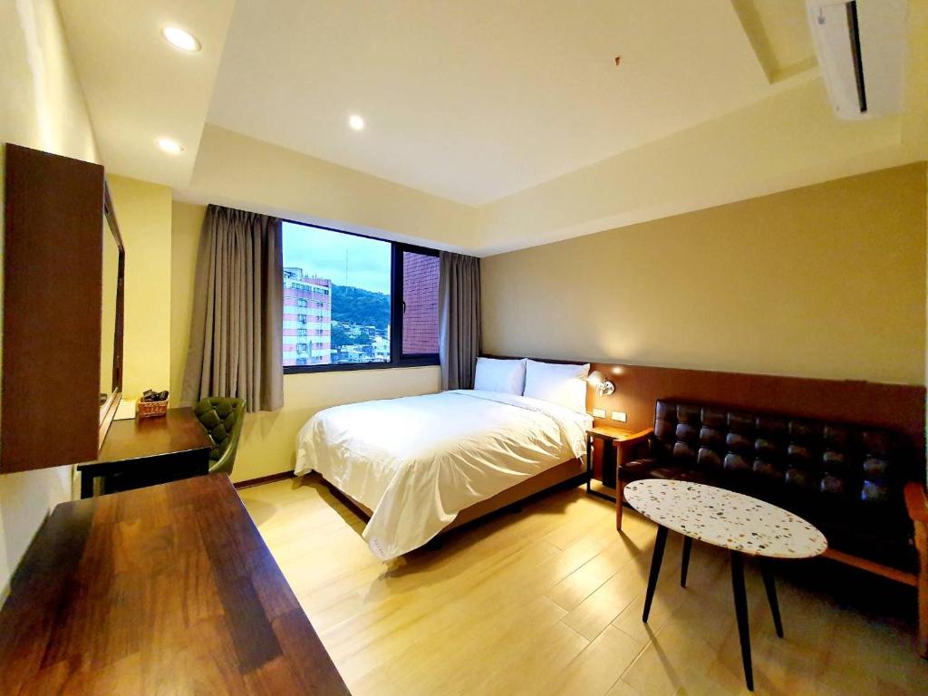 1 dormitorio con cama y ventana grande en 享住新大華館, en Keelung