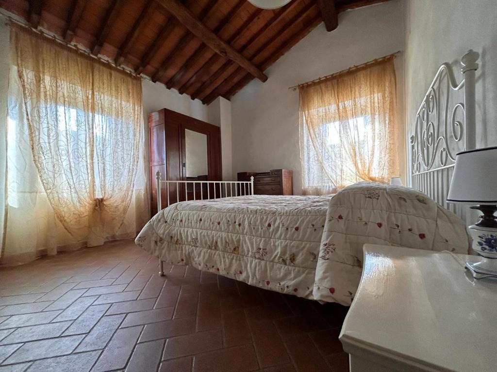 1 dormitorio con 1 cama y 2 ventanas en La casa del Tiglio, en Borgo San Lorenzo
