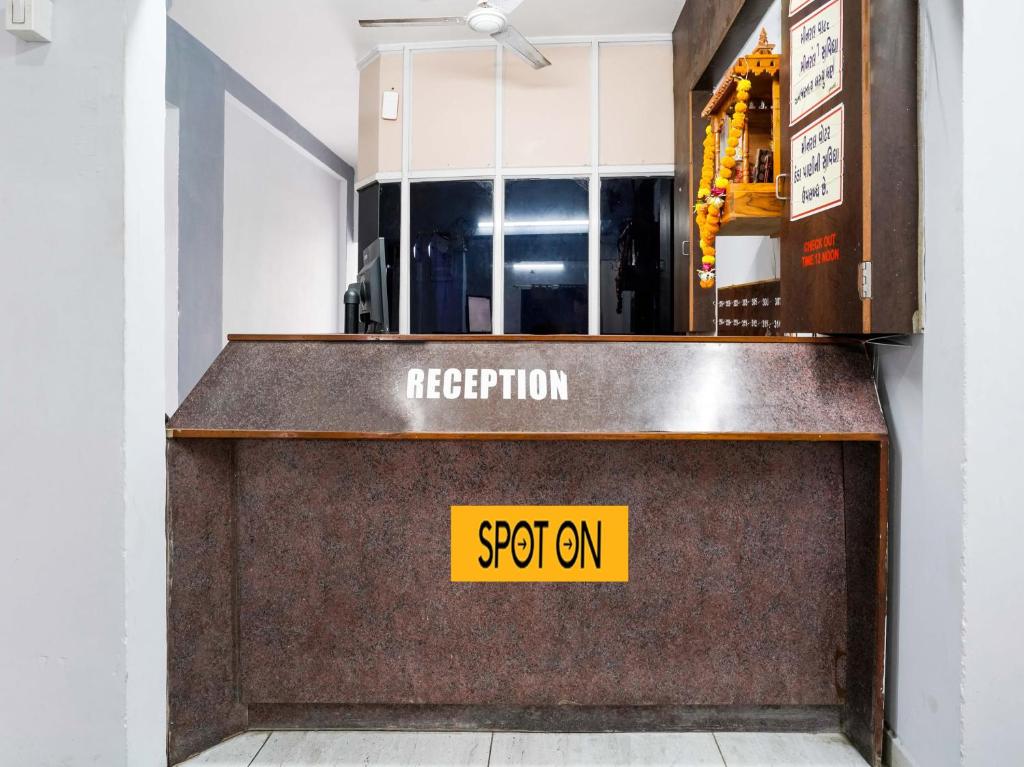 a reception desk with a yellow sign on it at OYO Hotel Moon in Rajkot