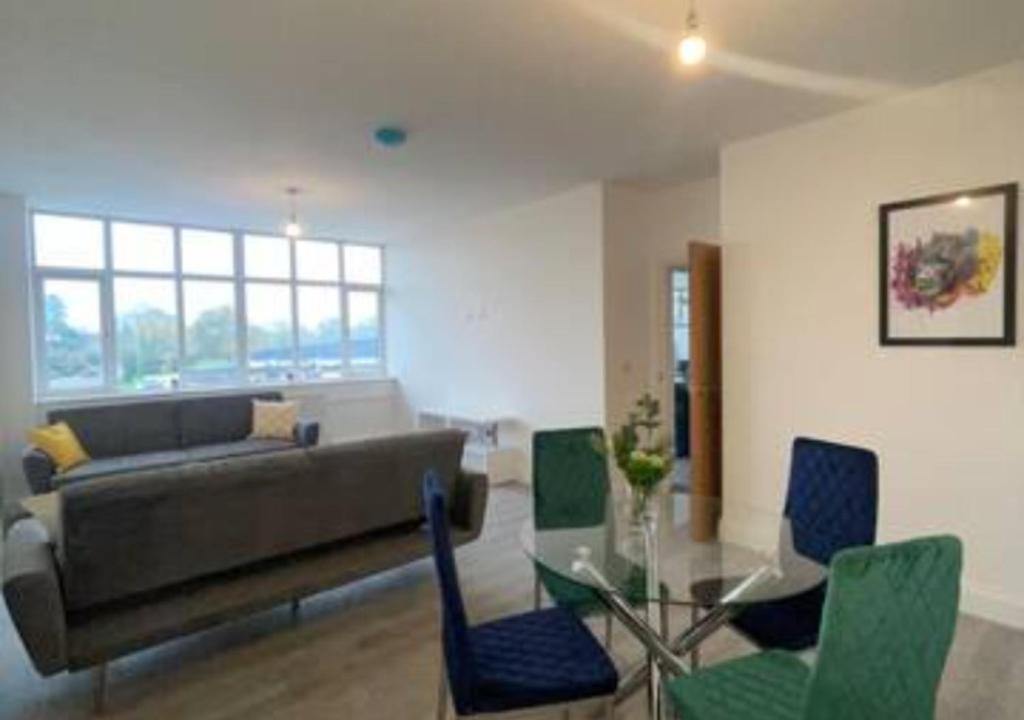 a living room with a couch and a glass table at Flitwick Luxury Apartment in Flitwick