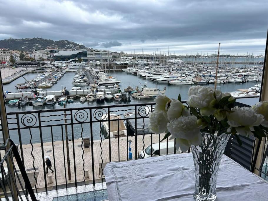un vase de fleurs sur une table avec un port dans l'établissement Cannes Vieux Port splendide vue, à Cannes