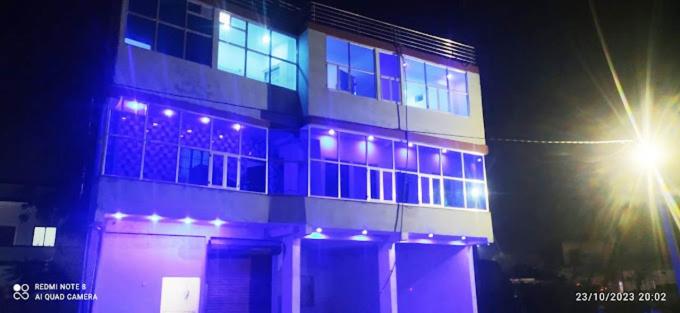 un bâtiment avec des lumières violettes devant un feu de rue dans l'établissement Hotel Krishna Inn, à Hindaun