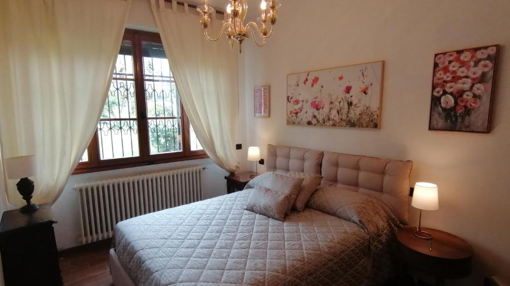 シルミオーネにあるVilla Paradisoのベッドルーム1室(ランプ2つ、窓付)