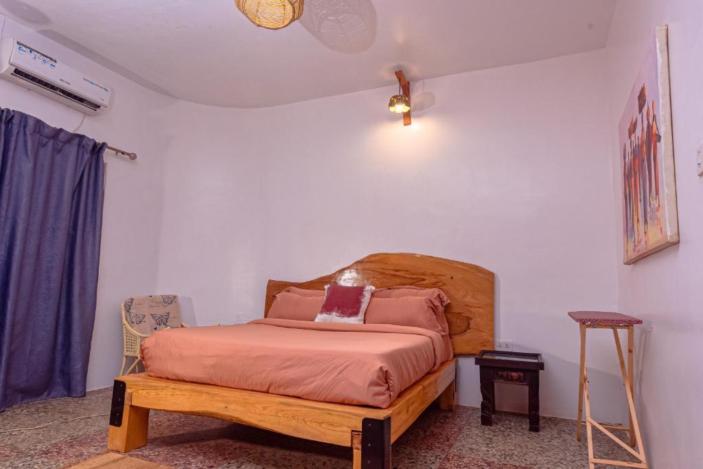 1 dormitorio con 1 cama con cabecero de madera en Bonsai Boutique Homes en Ibadán