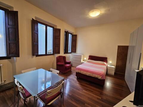 een slaapkamer met een bed, een tafel en een bank bij Six hills house in Montevarchi