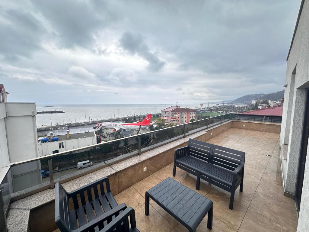 two benches on a balcony with a view of the ocean at Renaissance Apart Hotel in Trabzon