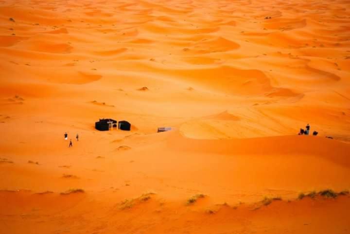 a group of people walking in the desert at Erg Chebbi Starlight Camp in Merzouga