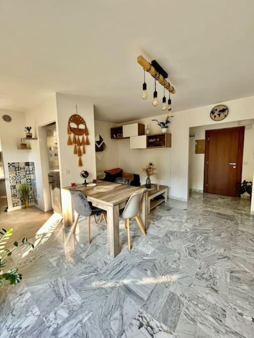 - un salon avec une table et des chaises sur un sol en marbre dans l'établissement Beau 2 pièces,Terrasse, Parking Menton Centre, à Menton
