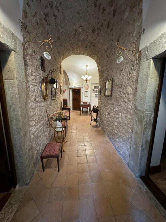 un corridoio in un castello con tavolo e sedie di Le Prigioni del Palazzo B&B a Sora