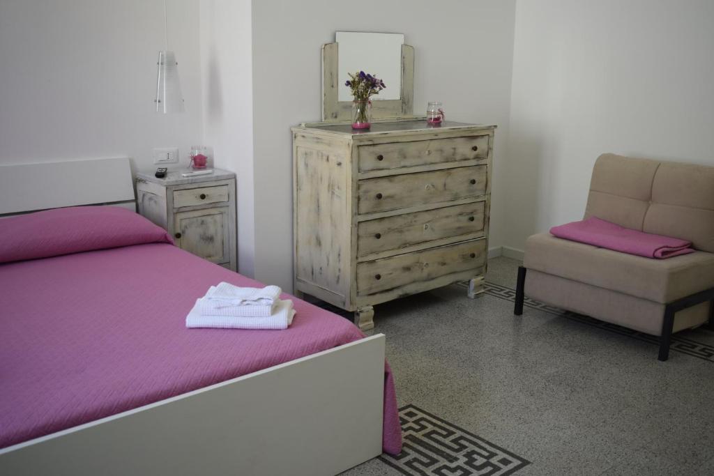 - une chambre avec un lit, une commode et une chaise dans l'établissement Il Borgo civ.15, à Paola
